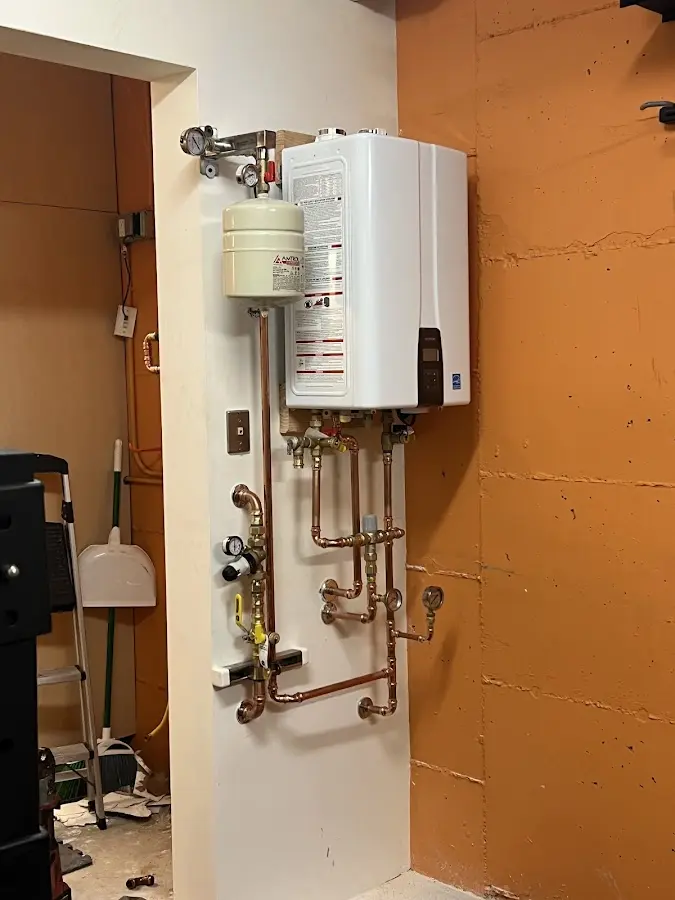 Plumbing technician inspecting water heater connections in Crosby